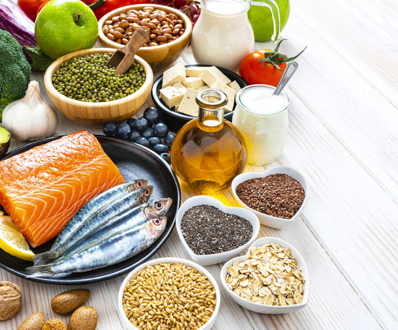 Foto com vários alimentos saudáveis, entre eles salmão, mirtilo, azeite e maçã