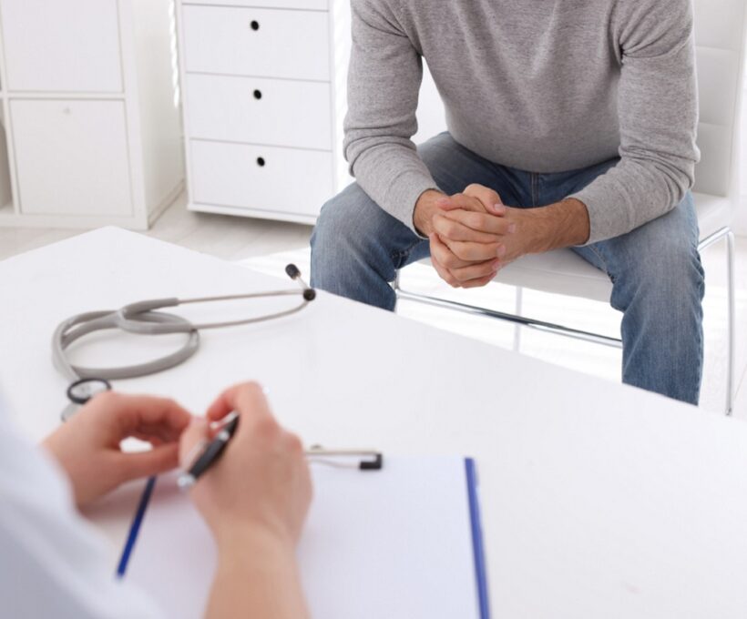 Homem sentado tirando dúvidas em consulta com médico