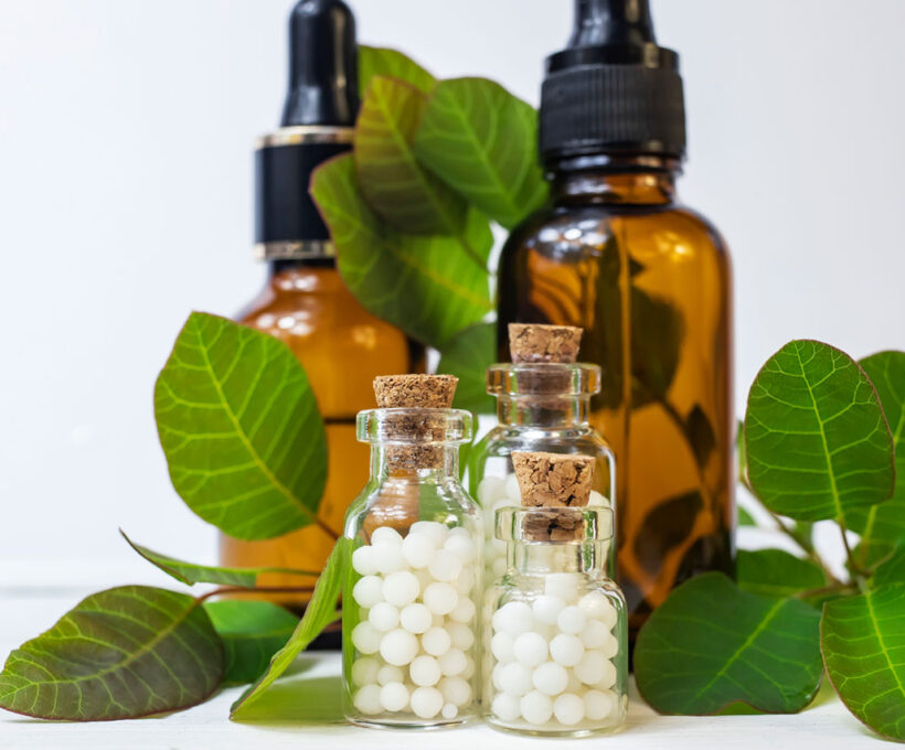Frascos de homeopatia e folhas ao fundo